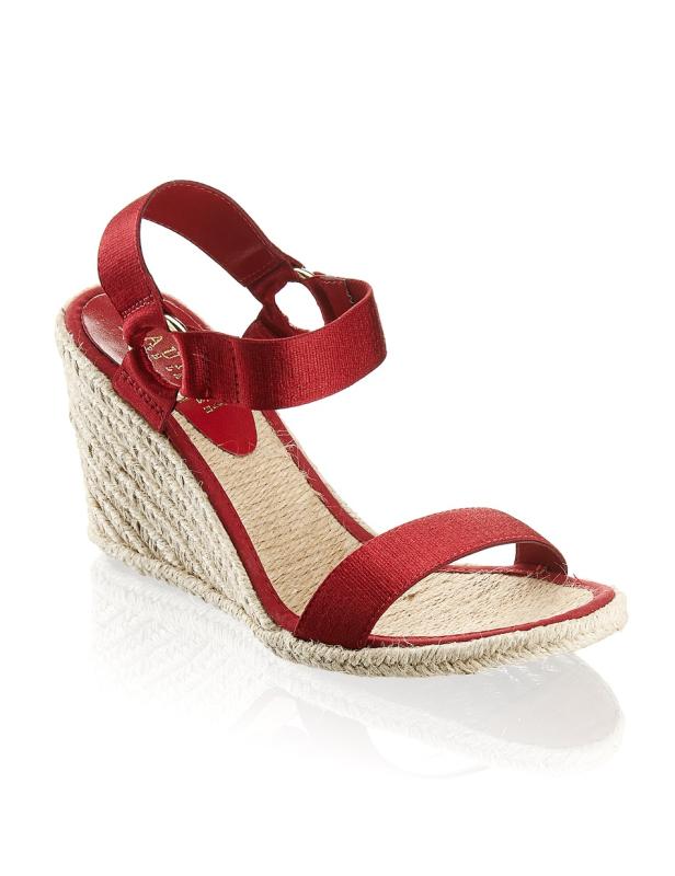 Eine rote Sandale mit Keilabsatz und Bastsohle.