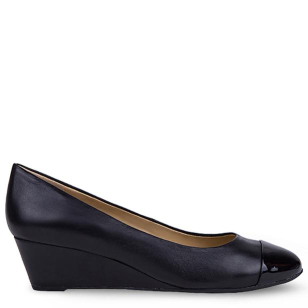 Ein schwarzer Damenschuh mit kleinem Keilabsatz und Lackleder-Kappe.