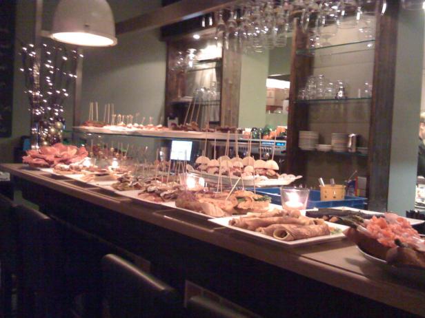 Eine Theke ist mit verschiedenen Tapas und kleinen Gerichten belegt.