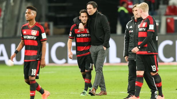 Ein Trainer umarmt einen Fußballspieler auf dem Spielfeld.