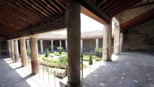 Ein Innenhof mit Säulen und einem kleinen Garten in Pompeji.