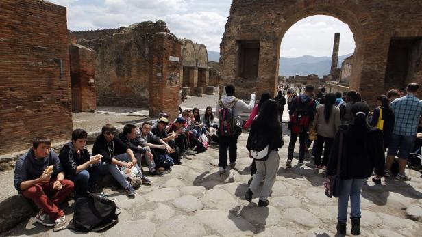 Eine Gruppe von Touristen besucht die Ruinen von Pompeji.