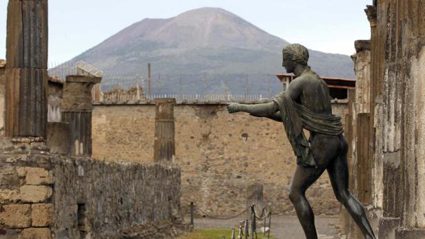 Eine Statue in Pompeji mit dem Vesuv im Hintergrund.