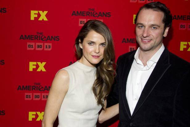 Keri Russell und Matthew Rhys posieren vor einer Wand für die Fernsehserie „The Americans“.