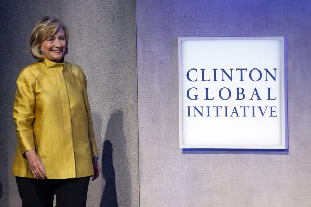 Hillary Clinton neben einem Schild der Clinton Global Initiative.