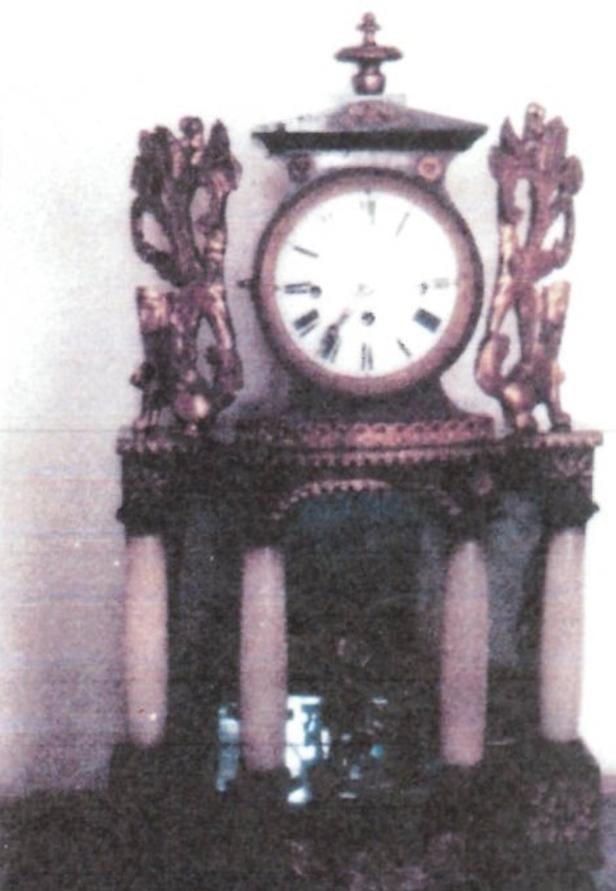 Eine antike Tischuhr mit Säulen und dekorativen Figuren an den Seiten.