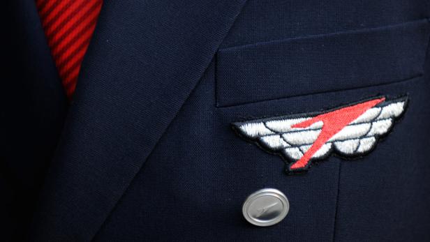 Die Uniform eines AUA Piloten Nahaufnahme der Uniform eines Flugbegleiters mit Anstecknadel und gestreifter Krawatte.