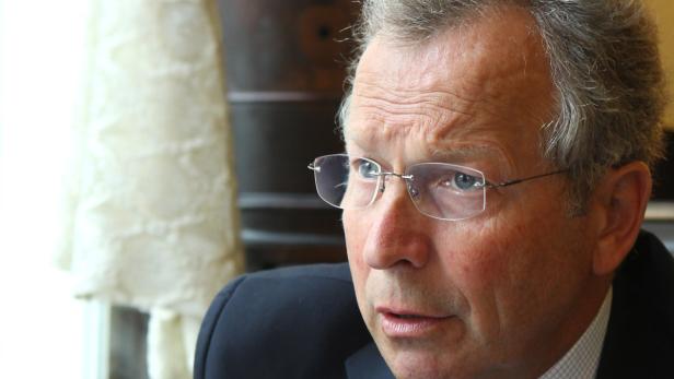 Ein Mann mit Brille und Anzug schaut aufmerksam zur Seite.