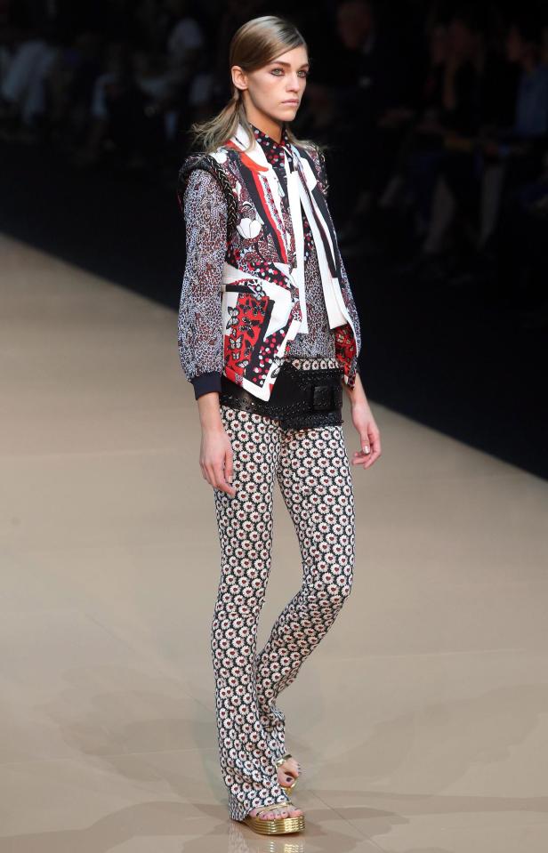 Eine Frau präsentiert Mode mit Blumenmuster auf dem Laufsteg.