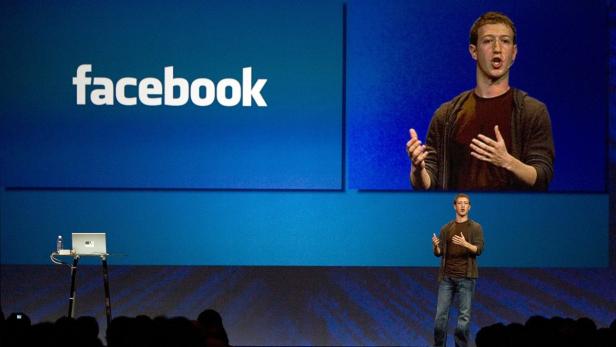 Mark Zuckerberg hält eine Präsentation vor dem Facebook-Logo.