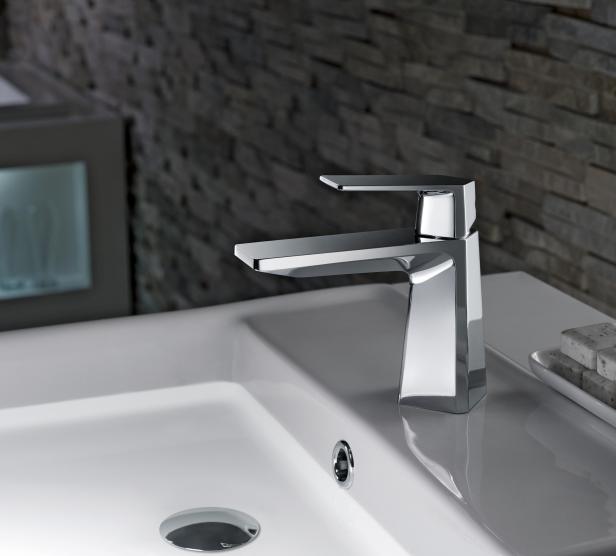 Ein moderner, verchromter Wasserhahn auf einem weißen Waschbecken.
