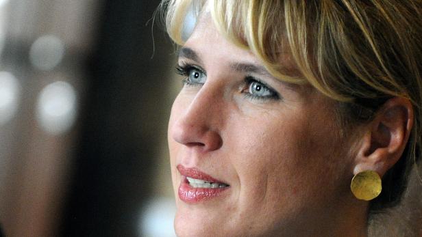 Nahaufnahme einer Frau mit blonden Haaren und goldenen Ohrringen.