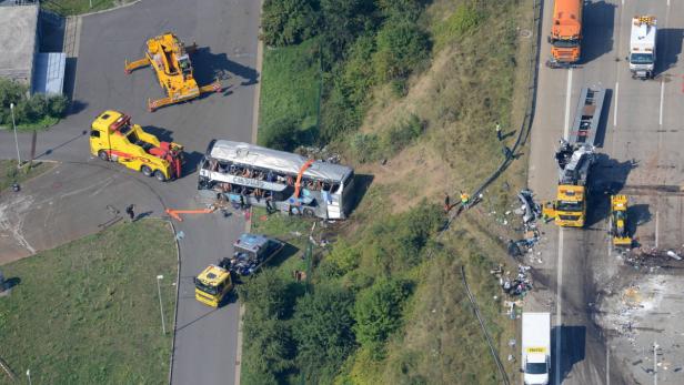 Ein Reisebus und ein LKW sind in einen Unfall auf einer Autobahn verwickelt; Bergungsarbeiten sind im Gange.