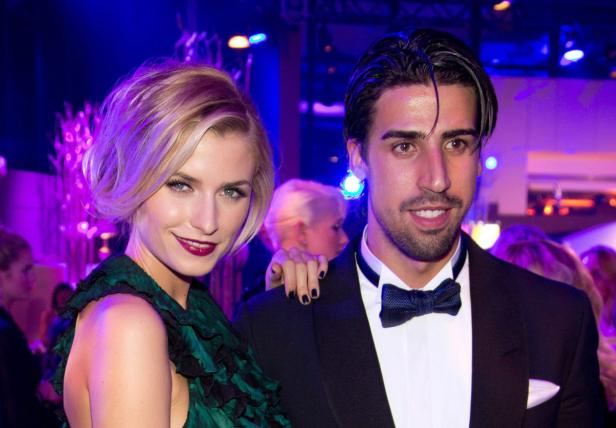 Eine Frau in einem grünen Kleid posiert mit einem Mann im Smoking.