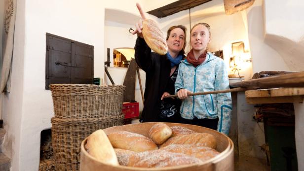 Zwei Frauen in einer Bäckerei betrachten ein Brotlaib.