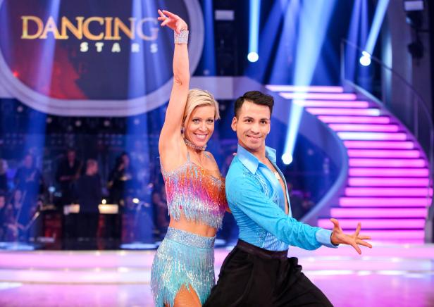 Ein Tanzpaar in glitzernden Kostümen auf der Bühne von „Dancing Stars“.