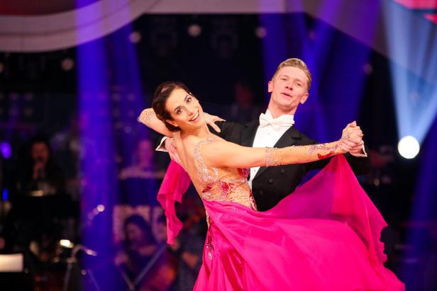 Ein Tanzpaar führt auf einer Bühne einen Standardtanz auf.