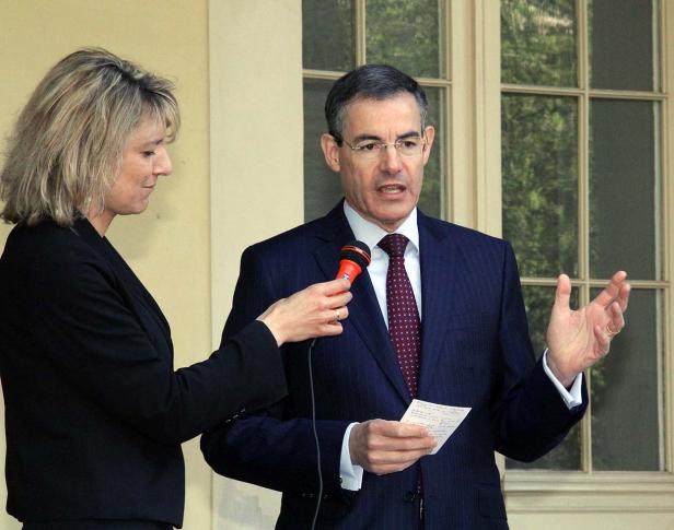 Ein Mann im Anzug spricht in ein Mikrofon, das von einer Frau gehalten wird.