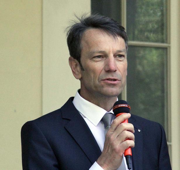 Ein Mann im Anzug spricht in ein Mikrofon.