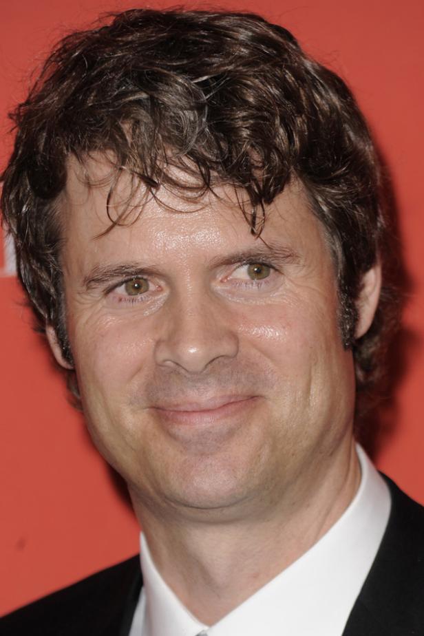 Porträt von Regisseur Peter Farrelly vor einem roten Hintergrund.