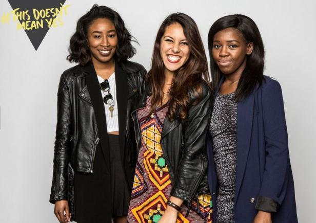 Drei junge Frauen posieren vor einer Wand mit dem Hashtag „This Doesn't Mean Yes“.