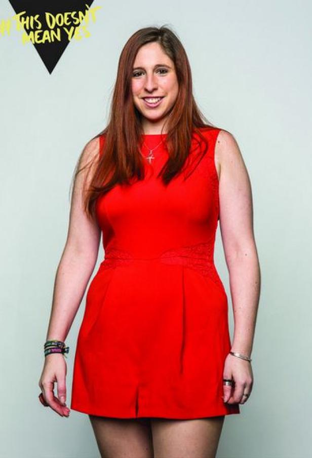 Eine Frau mit roten Haaren und einem roten Kleid lächelt in die Kamera.