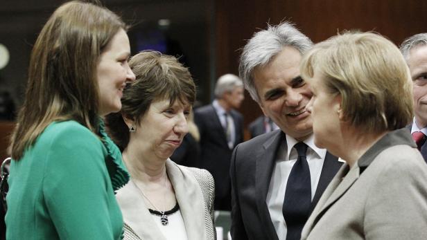 Krisengespräche: EU-Außenbeauftragte Ashton, Bundeskanzler Faymann und Kanzlerin Merkel (v. li.). Mehrere Personen, darunter Angela Merkel, unterhalten sich lächelnd.
