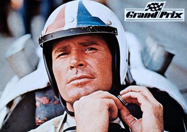 Ein Mann mit Rennfahrerhelm schliesst den Kinnriemen vor dem Grand Prix.