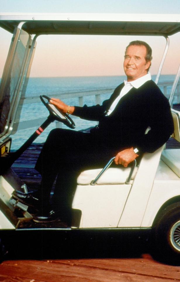 Ein Mann fährt einen Golfwagen am Meer entlang.