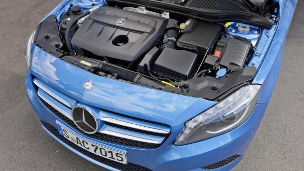 Der geöffnete Motorraum eines blauen Mercedes-Benz mit Blick auf den Motor.