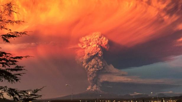 Ein Vulkan bricht unter einem orangefarbenen Himmel aus.