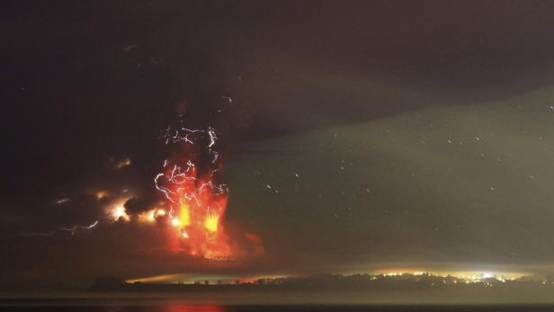 Blitze zucken über einem Vulkanausbruch in der Nacht.