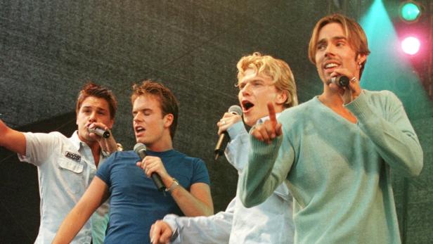 Die Boyband Caught in the Act tritt auf einer Bühne auf.