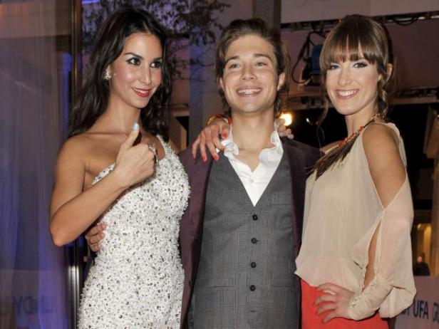 Drei Personen posieren auf einer Veranstaltung für ein Foto.