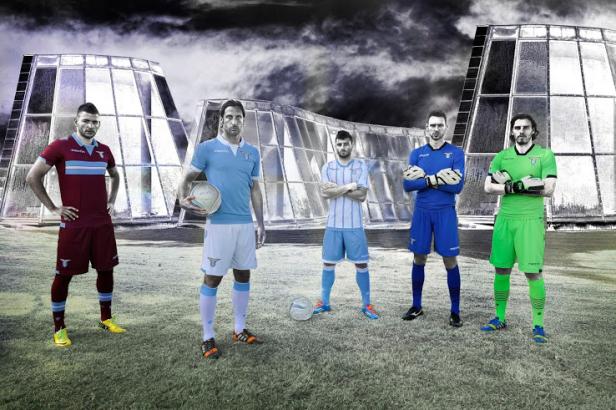 Fünf Fußballspieler von Lazio Rom posieren vor zwei futuristischen Gebäuden.
