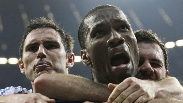 Didier Drogba wird von seinen Teamkollegen Frank Lampard und Paulo Ferreira umarmt.