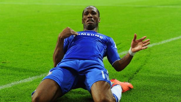 Didier Drogba kniet auf dem Rasen und jubelt.