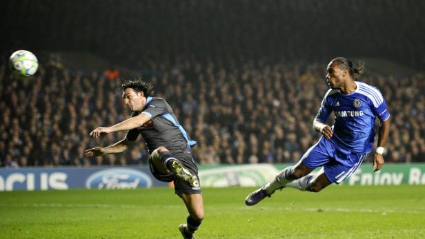 Zwei Fußballspieler kämpfen um den Ball vor einer Zuschauermenge.