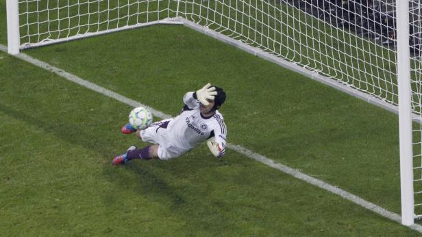 Ein Torwart hechtet, um einen Fußball zu halten.