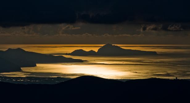 Silhouette von Inseln im goldenen Licht des Sonnenuntergangs.