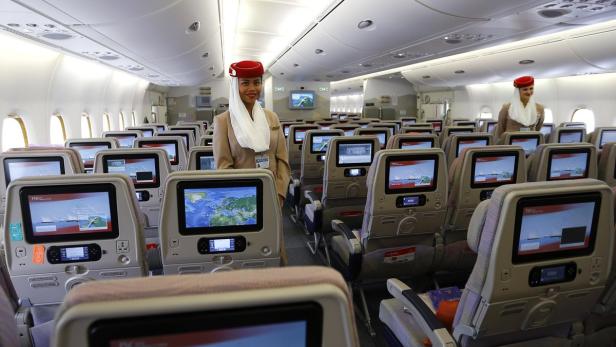 Eine Stewardess steht in der Kabine eines Emirates-Flugzeugs.