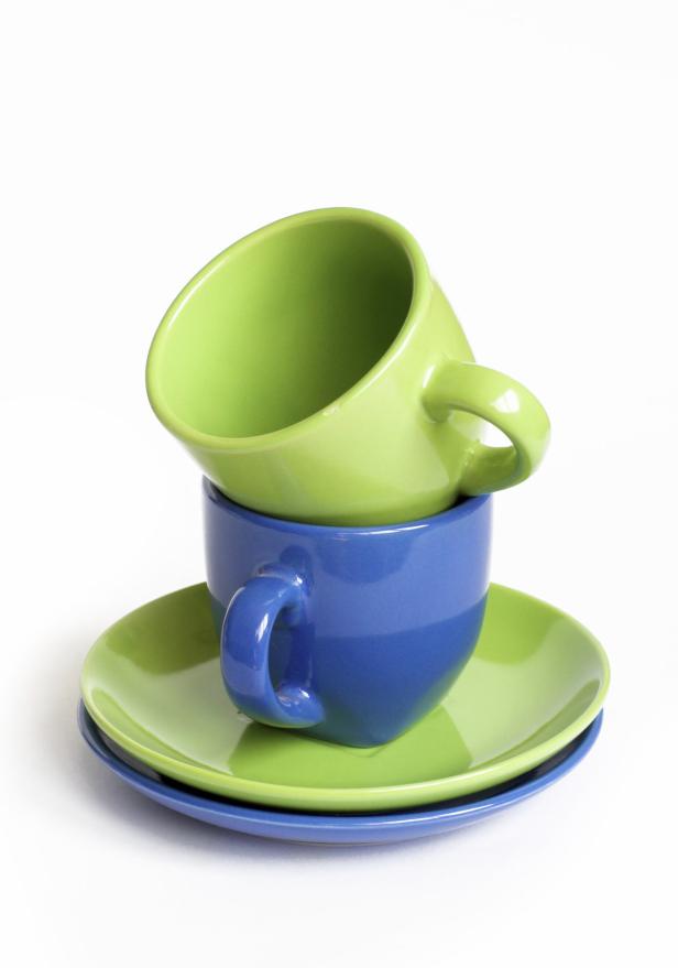 Ein Stapel aus einer grünen und einer blauen Tasse auf zwei Untertassen.