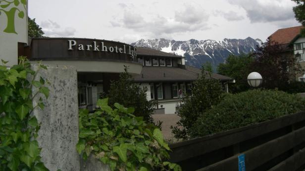 Das Parkhotel Igls vor einer Bergkulisse mit schneebedeckten Gipfeln.