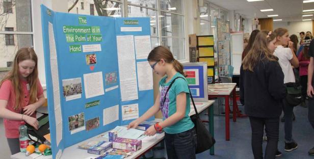 Zwei Mädchen stehen an einem Stand mit dem Thema „Die Umwelt liegt in deiner Hand“.