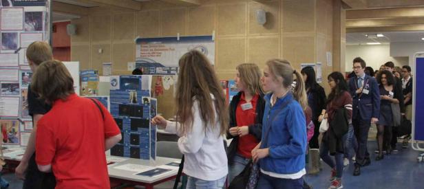 Besucher auf einer Wissenschafts- und Technikmesse betrachten Ausstellungen.
