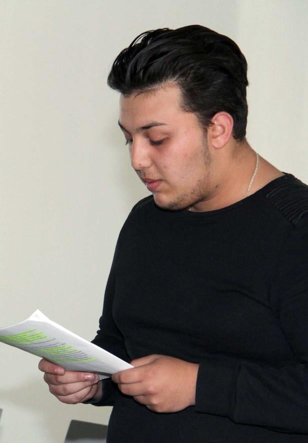 Ein junger Mann liest ein Dokument mit Markierungen.