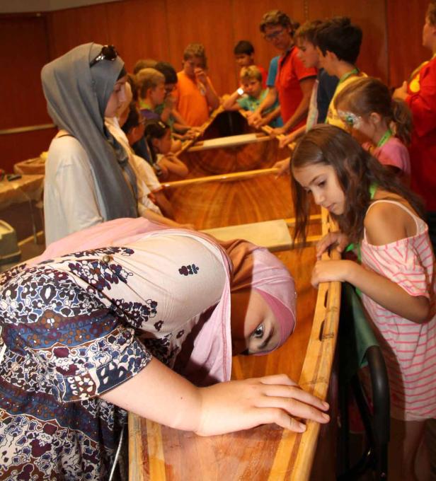Eine Gruppe von Kindern baut ein Holzboot.