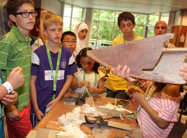 Eine Gruppe Kinder arbeitet an einem Projekt mit Holz und anderen Materialien.