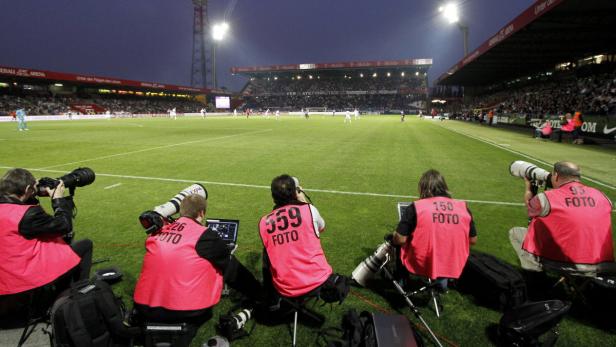 Fotografen beobachten ein Fußballspiel im Stadion.