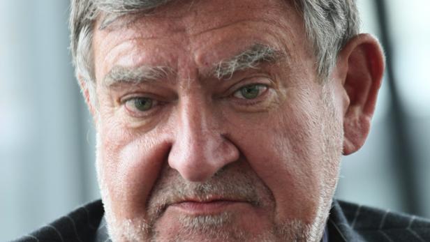 "Ein Austritt aus dem Euro würde zu einer extremen Verschlechterung in Griechenland führen“, sagt Herbert Stepic, Chef der RBI . Nahaufnahme eines Mannes mit grauen Haaren und Bart, der in die Kamera blickt.